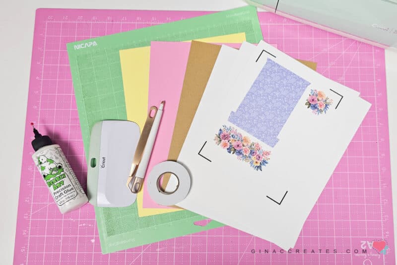 Cricut Explore cutting machine, white card stock, foam tape, craft glues, and other supplies needed for creating a Springtime window card.